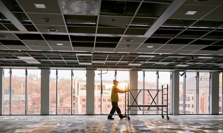 bygningsarbeider triller stillas gjennom tom bygning